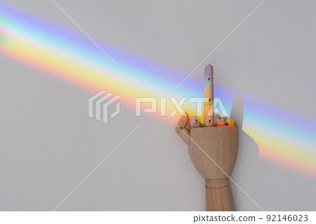 Wooden hand showing fuck you gesture on LGBT community rainbow flag Wooden hand showing fuck you gesture on LGBT community rainbow flag 92146023