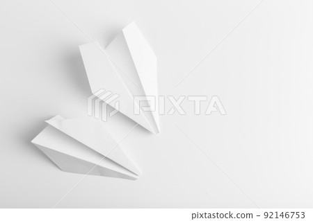 Flat lay of white paper plane on white color background Flat lay of white paper plane on white color background 92146753