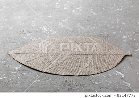 Perspective view of leaf shaped tablecloth for food on cement background. Empty space for your design. 92147772