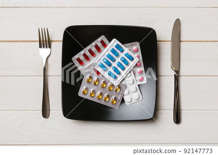 Many different weight loss pills and supplements as food on round plate. Pills served as a healthy meal. Drugs, pharmacy, medicine or medical healthycare concept 92147773