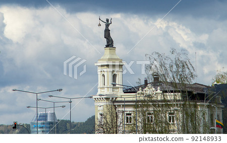 Statue of a woman with a lantern and a raised hand at the building of a former power station in Vilnius. 92148933