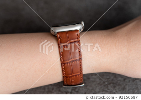 Wearable device wrapped around a woman's arm Brown leather belt watch 92150687