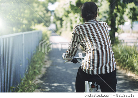 Woman riding a bicycle Woman riding a bicycle 92152112