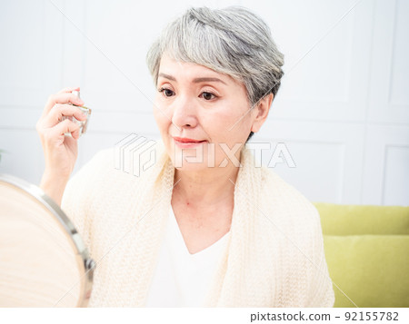 60 A perfume-like portrait of a mature woman in a bedroom. 92155782