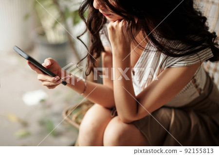 Woman Checking Messages in Smartphone Woman Checking Messages in Smartphone 92155813