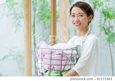 A young lady with a laundry basket A young lady with a laundry basket 92155862