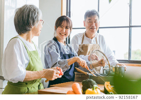 Elderly couple cooking in the kitchen and young Japanese woman (housekeeping / nursing care) Elderly couple cooking in the kitchen and young Japanese woman (housekeeping / nursing care) 92158167