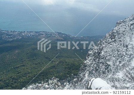 Picturesque view of the city of Yalta and Black Sea from covered snow top of Ai Petri mountain in Crimea Picturesque view of the city of Yalta and Black Sea from covered snow top of Ai Petri mountain in Crimea 92159112
