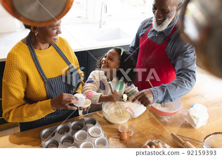 Image of happy african american grandparents and granddaughter baking in kitchen Image of happy african american grandparents and granddaughter baking in kitchen 92159393