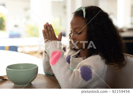 Image of african american girl praying before meal Image of african american girl praying before meal 92159456