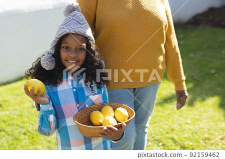 Image of happy african american girl with grandmother holding bowl with lemons Image of happy african american girl with grandmother holding bowl with lemons 92159462