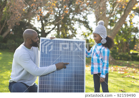 Image of happy african american father showing solar panels to daughter Image of happy african american father showing solar panels to daughter 92159490