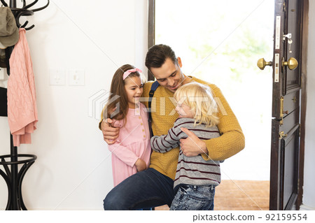 Image of caucasian father returning home from work and welcoming with children 92159554