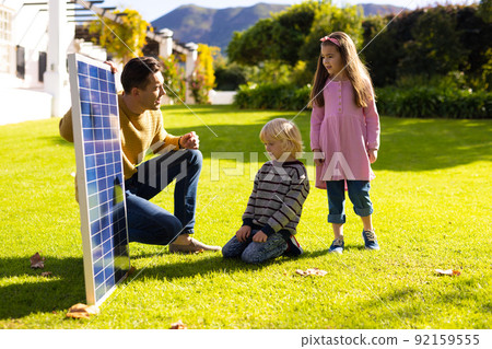 Image of caucasian father showing solar panel to children Image of caucasian father showing solar panel to children 92159555