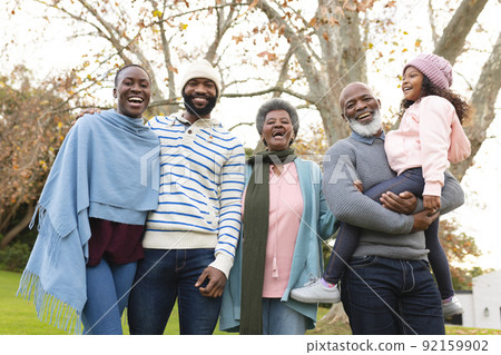 Image of happy multi generation african american family posing at camera outdoors in autumn 92159902