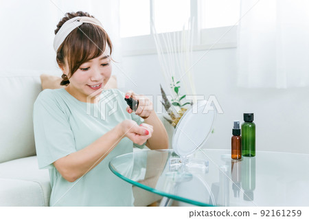 Japanese woman wearing a perfume / insect repellent / sunscreen spray (scent) Japanese woman wearing a perfume / insect repellent / sunscreen spray (scent) 92161259