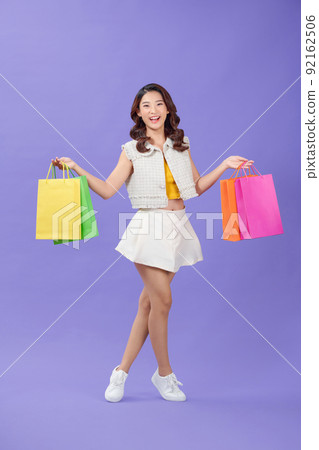young woman happy positive smile go walk hold shopping bags sale isolated over purple background young woman happy positive smile go walk hold shopping bags sale isolated over purple background 92162506