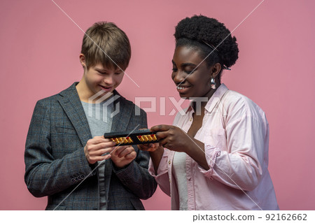 Woman showing arithmetic on abacus to disabled guy 92162662