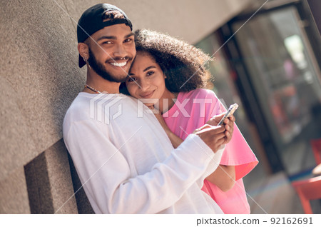 Young man in a black cap and a woman in pink tshirt in the street Young man in a black cap and a woman in pink tshirt in the street 92162691