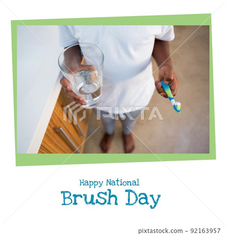 Low section of african american boy holding toothbrush and water and happy national brush day text Low section of african american boy holding toothbrush and water and happy national brush day text 92163957
