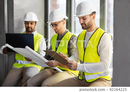 male architects in helmets working at office 92164225
