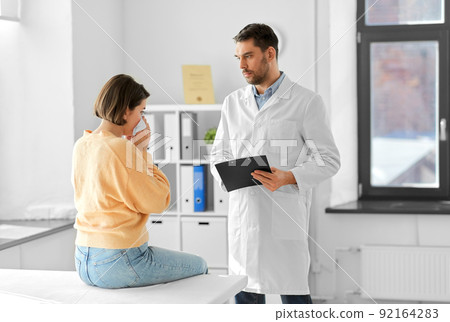 male doctor and woman blowing nose at hospital 92164283