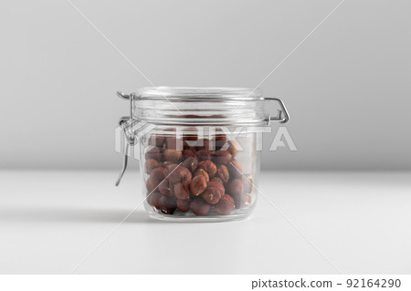 close up of jar with hazelnuts on white table 92164290