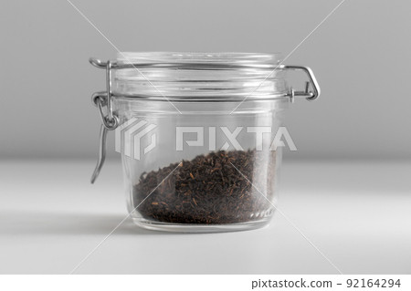 close up of jar with black tea on white table close up of jar with black tea on white table 92164294