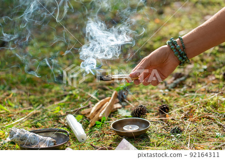 woman or witch performing magic ritual in forest 92164311