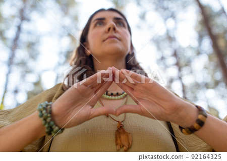 woman or witch performing magic ritual in forest 92164325