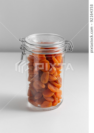 close up of jar with dried apricot on white table close up of jar with dried apricot on white table 92164358