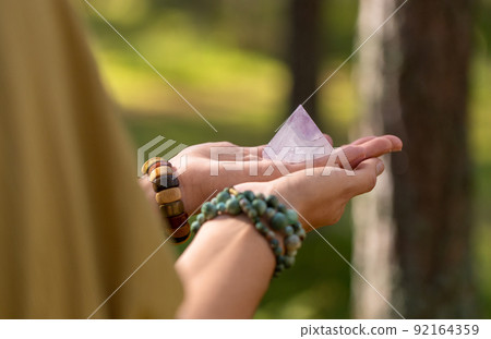 close up of hands holding crystal pyramid close up of hands holding crystal pyramid 92164359