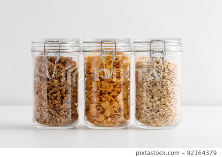 close up of jars with oat, corn flakes and granola 92164379