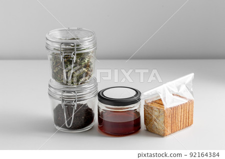 jars with dried herb, tea, honey and cookies 92164384