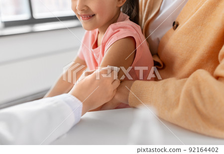 doctor preparing child for vaccination at clinic doctor preparing child for vaccination at clinic 92164402