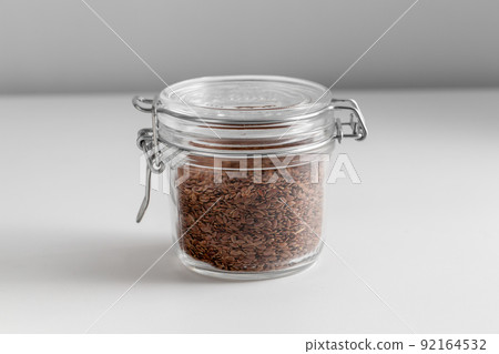 close up of jar with flax seeds on white table 92164532