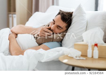sick man coughing in bed at home 92164564
