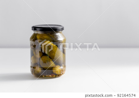 close up of jar with pickled cucumbers on table close up of jar with pickled cucumbers on table 92164574