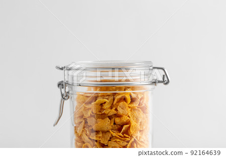 close up of jar with corn flakes on white table close up of jar with corn flakes on white table 92164639