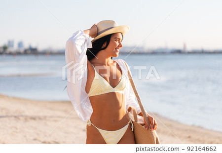 portrait of woman in bikini and hat on beach 92164662