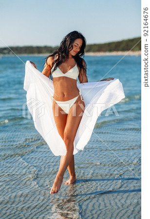 woman in bikini swimsuit with pareo on beach woman in bikini swimsuit with pareo on beach 92164676