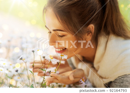 close up of woman smelling chamomile flowers 92164793
