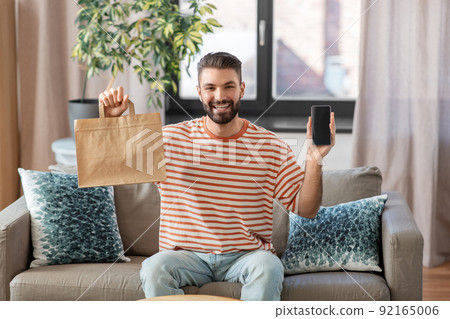 smiling man using smartphone for food delivery 92165006