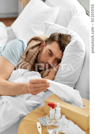 sick man lying in bed at home and taking tissue sick man lying in bed at home and taking tissue 92165058