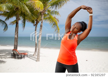 woman exercising on tropical beach 92165207