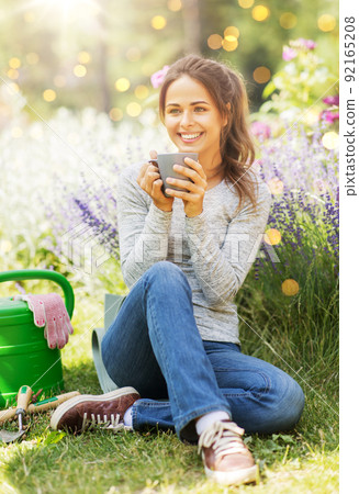 woman drinking tea or coffee at summer garden 92165208