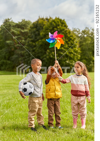 happy kids with pinwheel having fun at park 92165232
