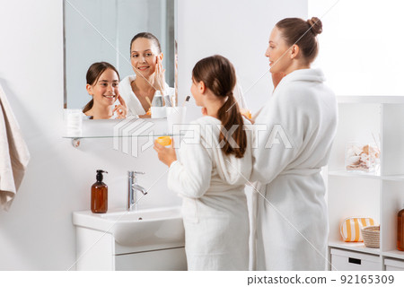 mother and daughter with moisturizer in bathroom 92165309