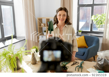 happy woman or blogger planting flowers at home 92165319