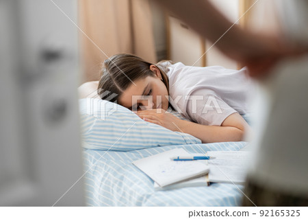 parent looking at student girl sleeping at home parent looking at student girl sleeping at home 92165325